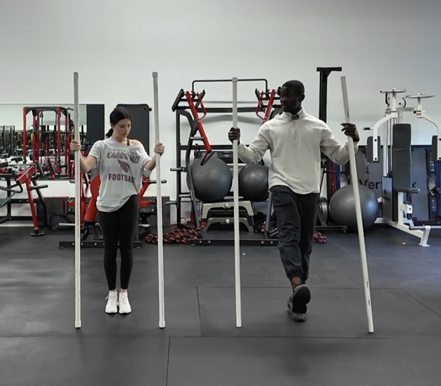 Oseoba coaching an athlete through a partner band walk in the gym